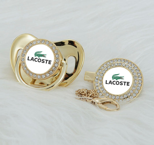 Premium Baby Schnuller Lacoste gold-weiß mit Clip & Geschenkbox