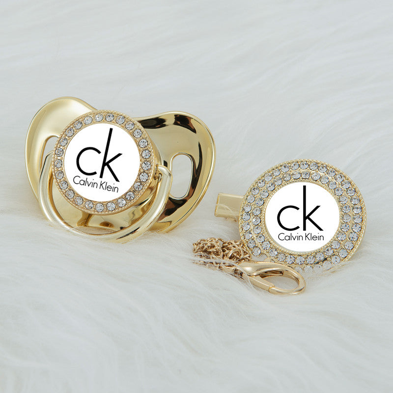 Premium Baby Schnuller Calvin Klein gold-weiß mit Clip & Geschenkbox